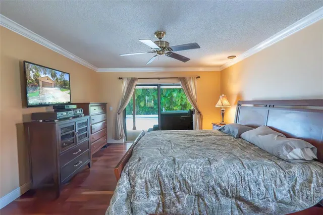 a bedroom with a large bed and a flat tv screen