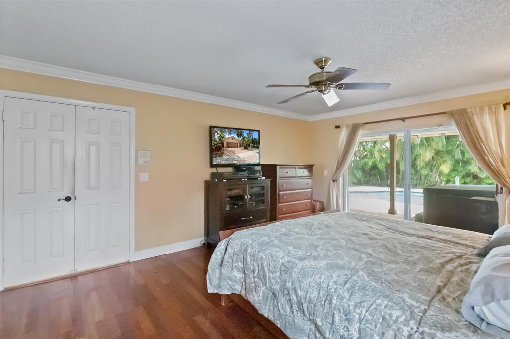 12626 Southwest 9th Place Davie, FL 33325 - Photo 8 of 26 a bedroom with a bed and a chandelier