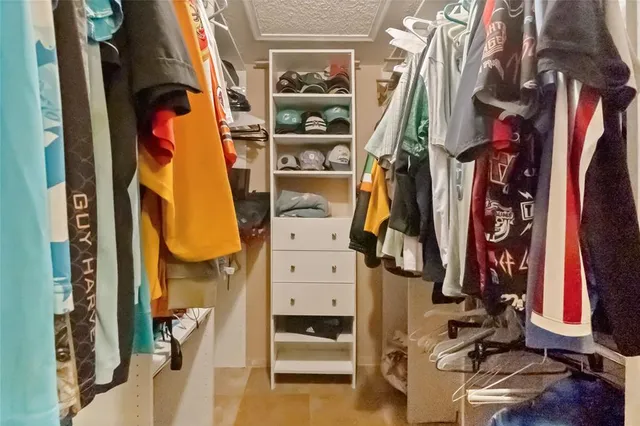 a view of walk in closet with clothes