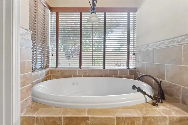 a bath tub sitting in a bathroom next to a window