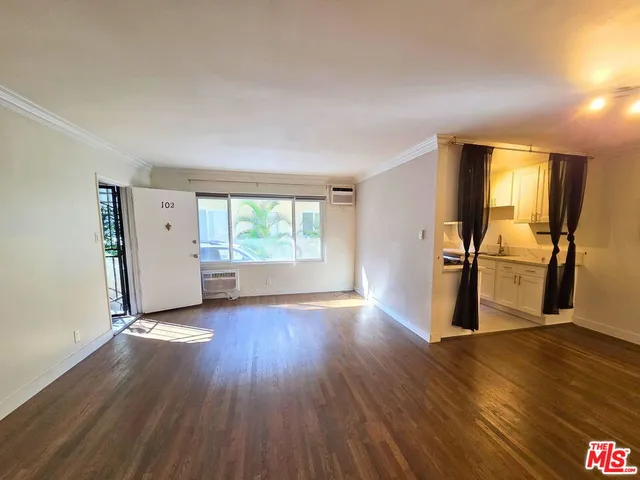 a view of a room with wooden floor and a window