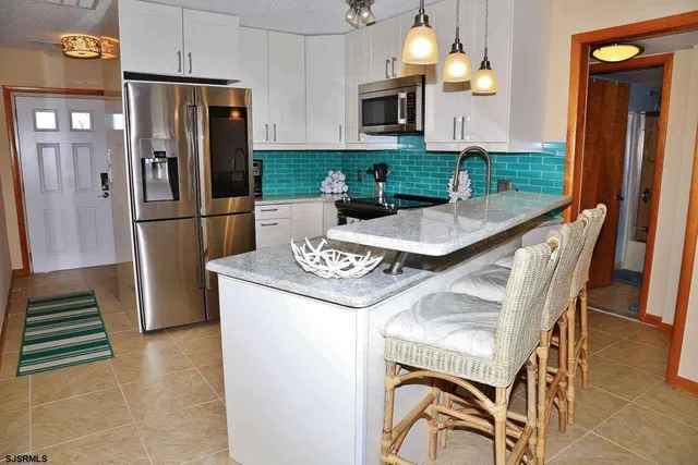 a kitchen with stainless steel appliances granite countertop a refrigerator a stove a sink dishwasher and wooden cabinets