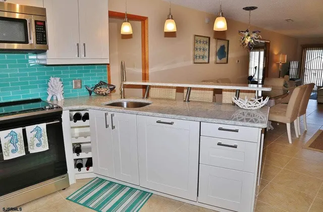 a kitchen with stainless steel appliances granite countertop a sink and a stove with wooden floor