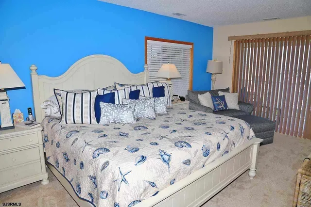 a large bed sitting in a bedroom next to a window