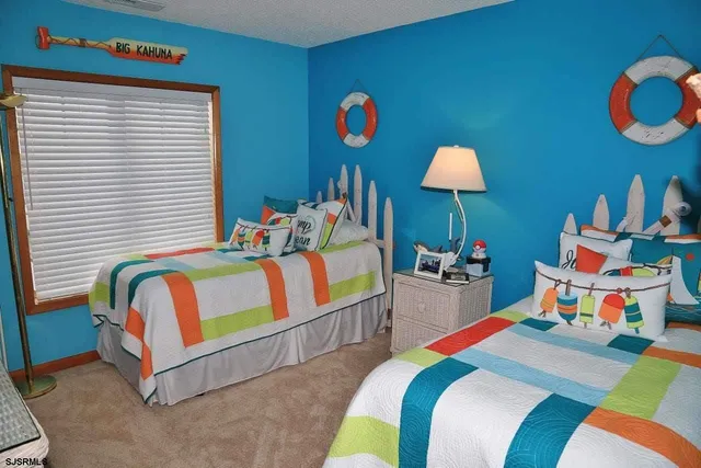 a bedroom with bed and a lamp on dresser