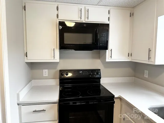 a kitchen with microwave cabinets and stove top oven