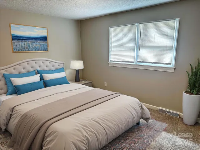 a bedroom with a large bed and a potted plant