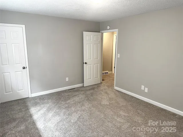 an empty room with closet and mirror