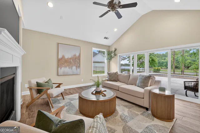 a living room with furniture a flat screen tv and a fireplace