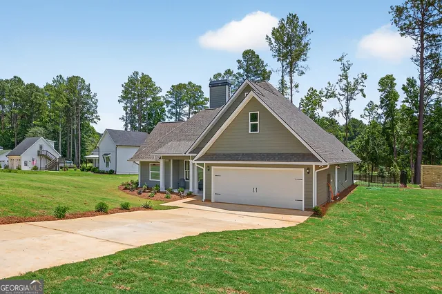 a front view of a house with a yard and trees