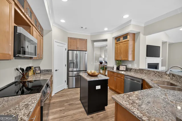 a kitchen with granite countertop kitchen island sink stove and wooden floor