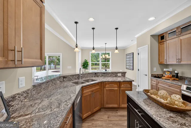 a kitchen with stainless steel appliances granite countertop a stove a sink and a microwave