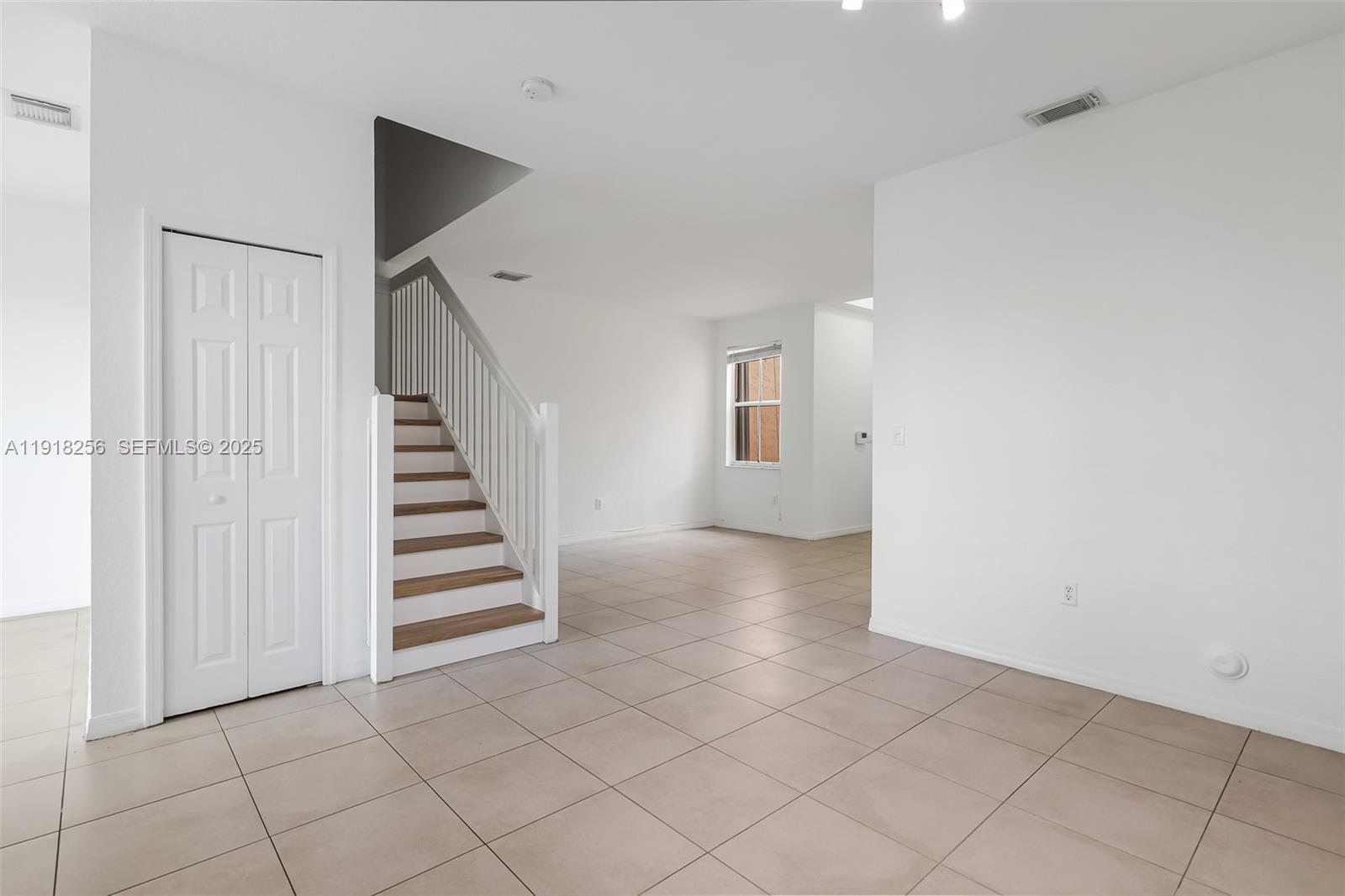 12566 Southwest 126th Avenue Miami, FL 33186 - Photo 24 of 59 a view of a livingroom with white walls and stairs