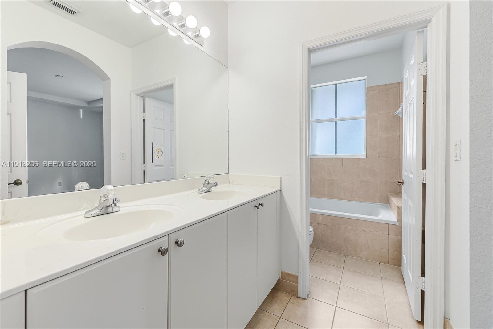 12566 Southwest 126th Avenue Miami, FL 33186 - Photo 36 of 59 a bathroom with a tub sink and mirror