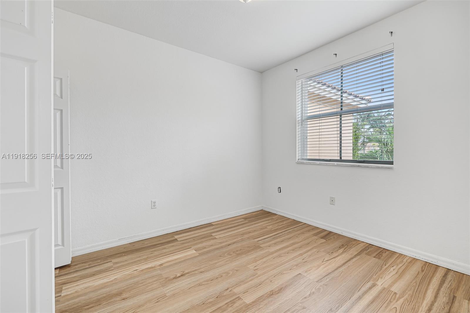 12566 Southwest 126th Avenue Miami, FL 33186 - Photo 40 of 59 an empty room with wooden floor and windows