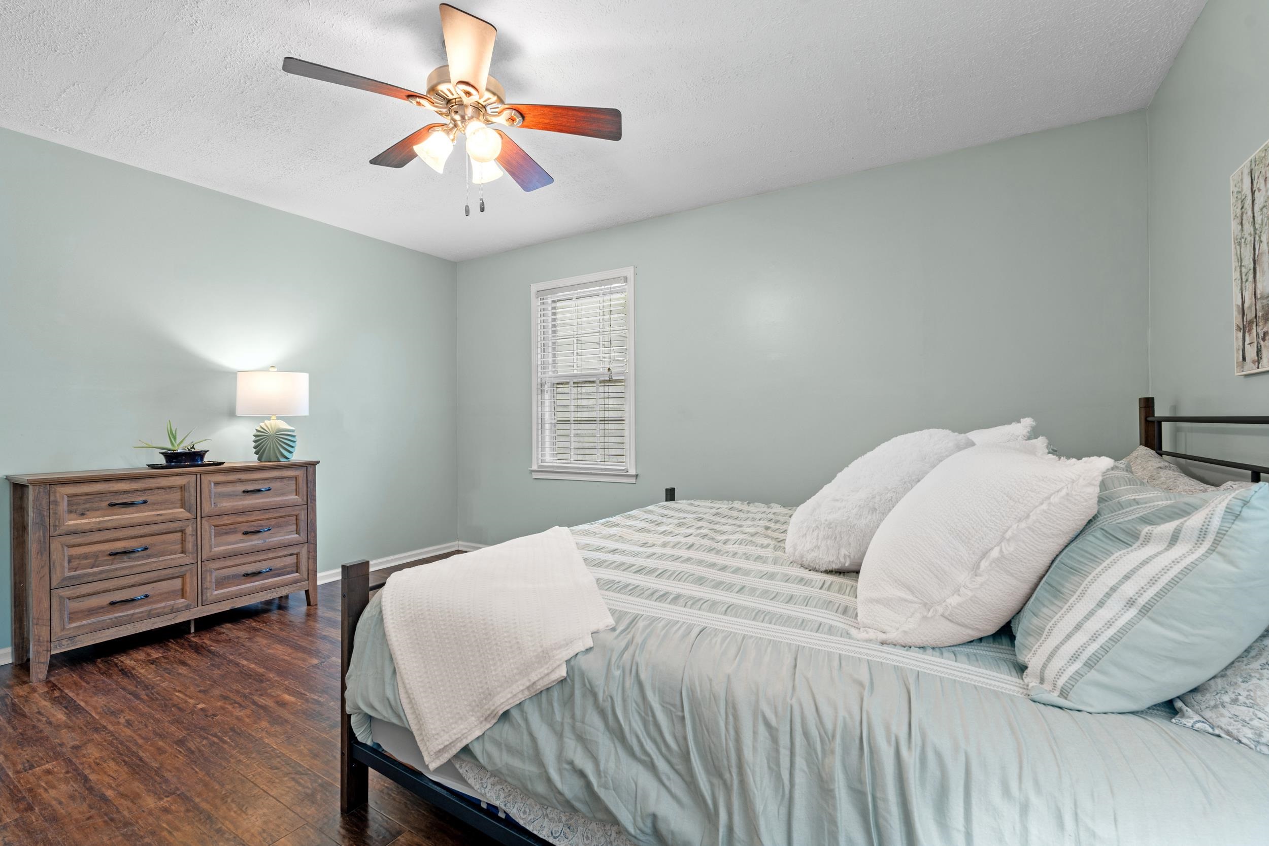 208 Bethea Street Latta, SC 29565 - Photo 14 of 36 Bedroom with a textured ceiling, dark wood finished floors, and ceiling fan