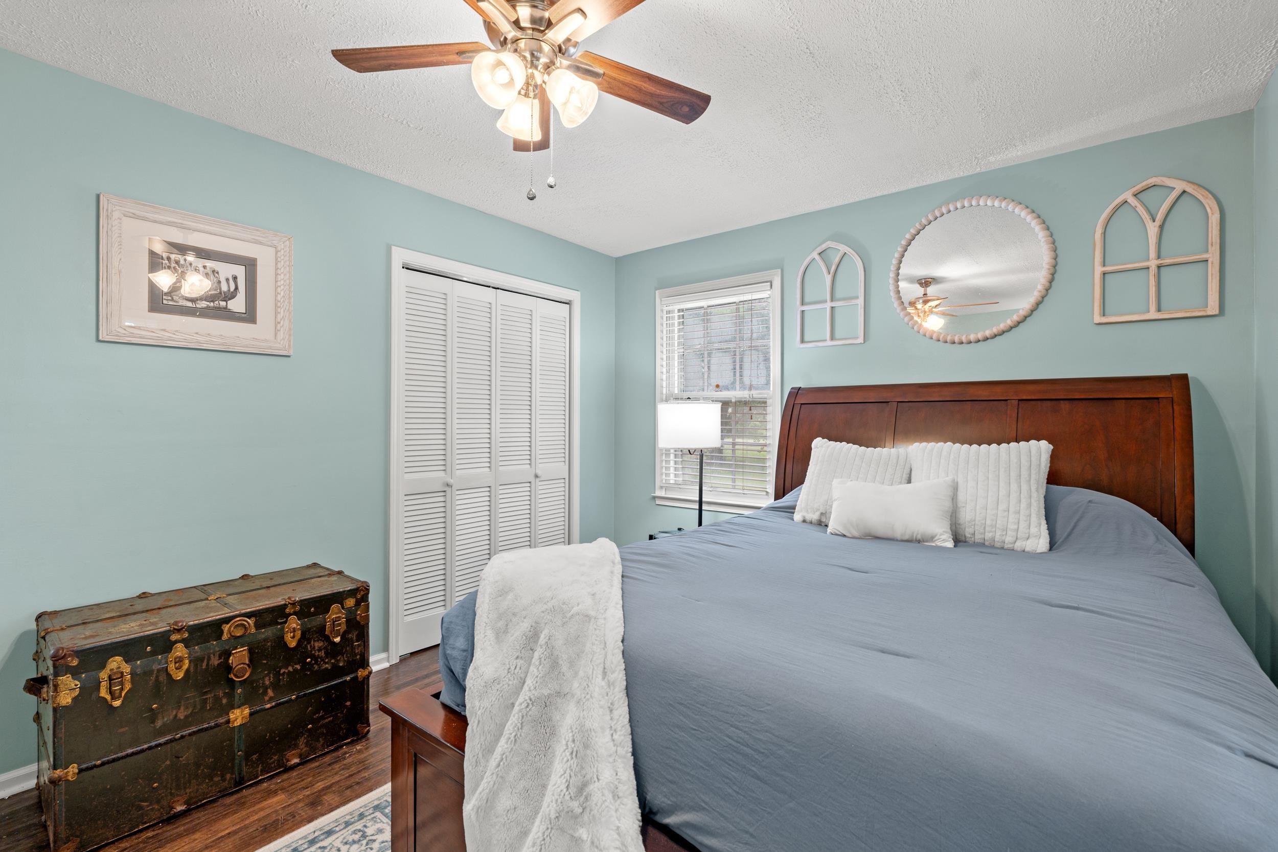 208 Bethea Street Latta, SC 29565 - Photo 18 of 36 Bedroom with a textured ceiling, a closet, ceiling fan, and wood finished floors