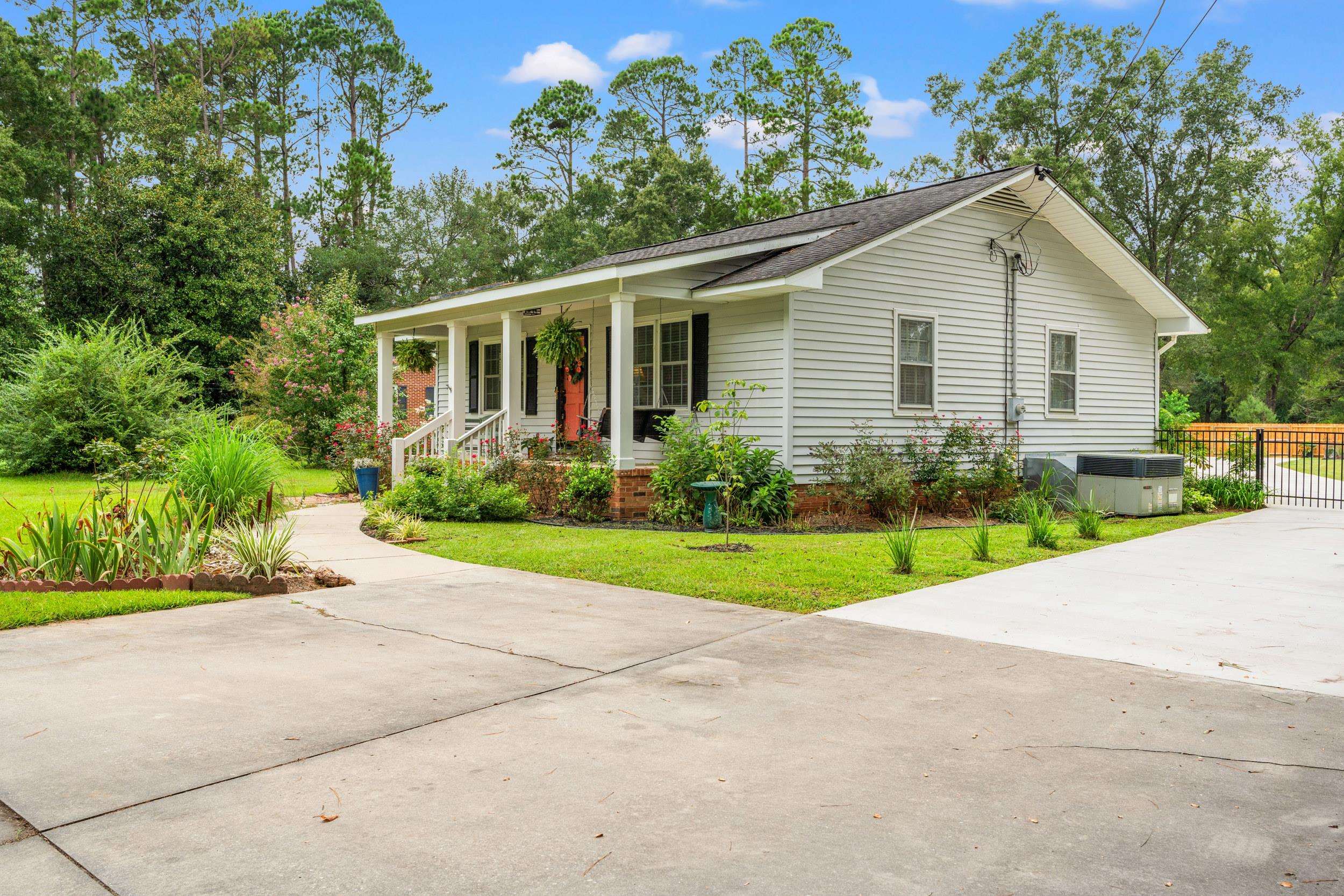 208 Bethea Street Latta, SC 29565 - Photo 3 of 36 View of front of home with a porch, a shingled roof, and driveway