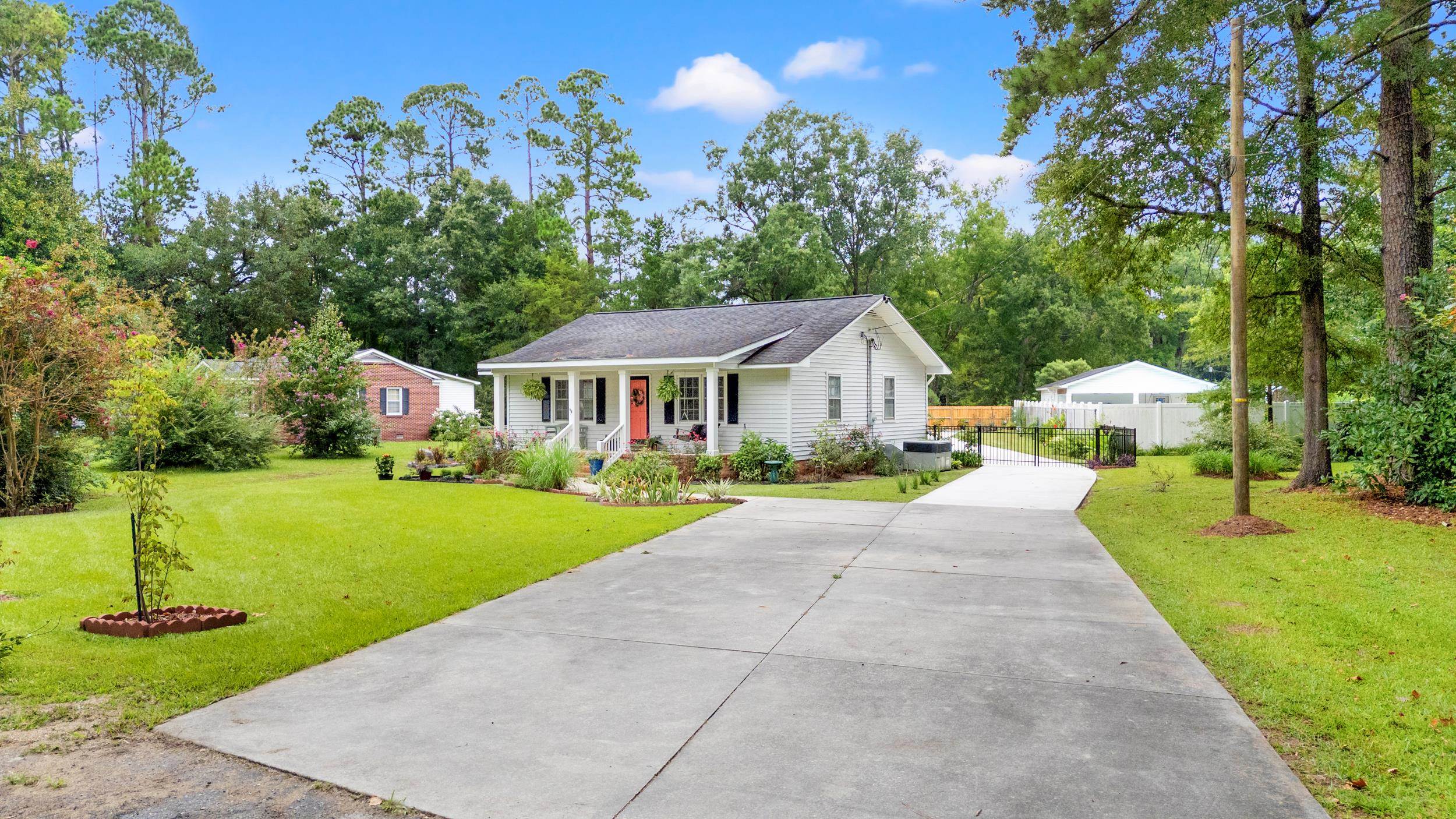 208 Bethea Street Latta, SC 29565 - Photo 33 of 36 Single story home featuring a porch, driveway, and view of scattered trees