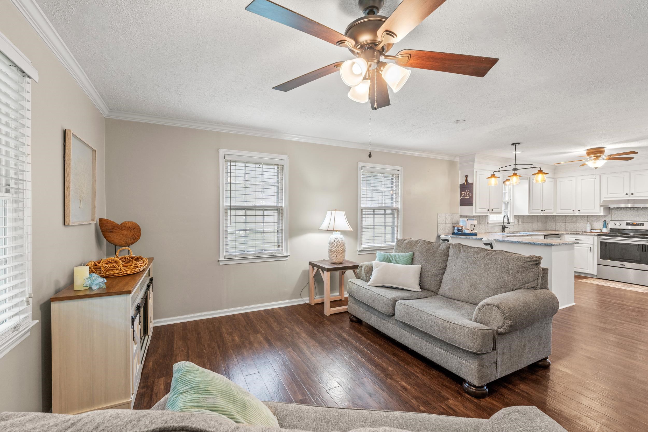 208 Bethea Street Latta, SC 29565 - Photo 7 of 36 Living area with crown molding, a textured ceiling, dark wood finished floors, and ceiling fan