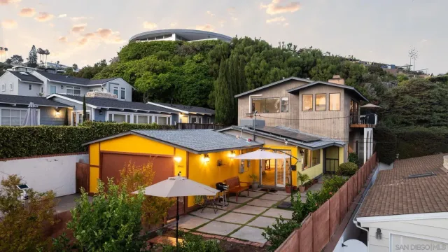 a view of a house with swimming pool next to a yard