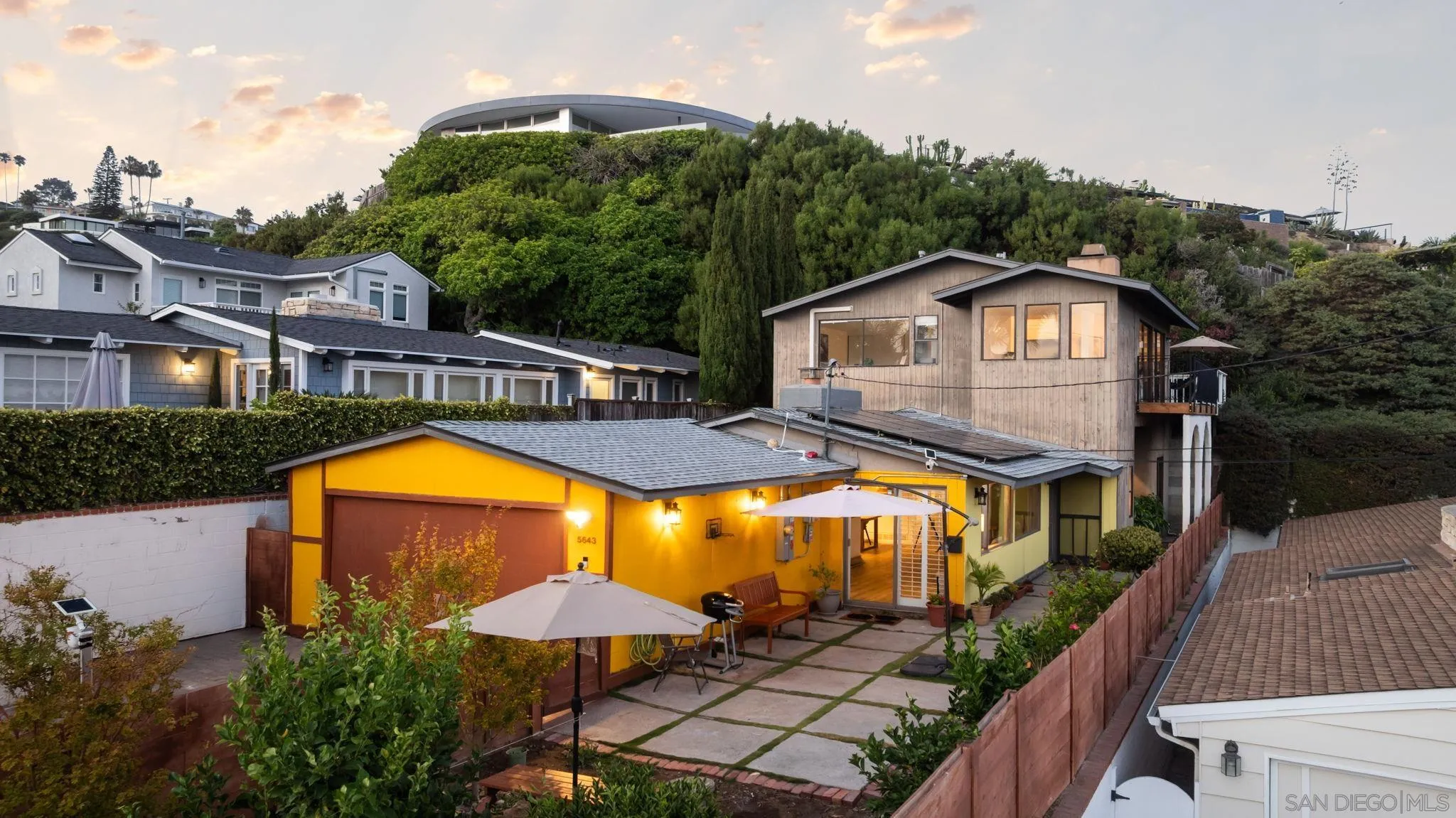 a view of a house with swimming pool next to a yard