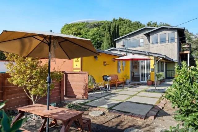 a view of a patio with table and chairs under an umbrella
