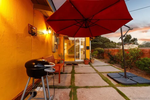 a view of a patio with table and chairs under an umbrella