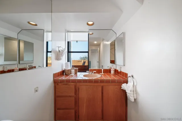 a en suite bathroom with a granite countertop shower a sink and a mirror