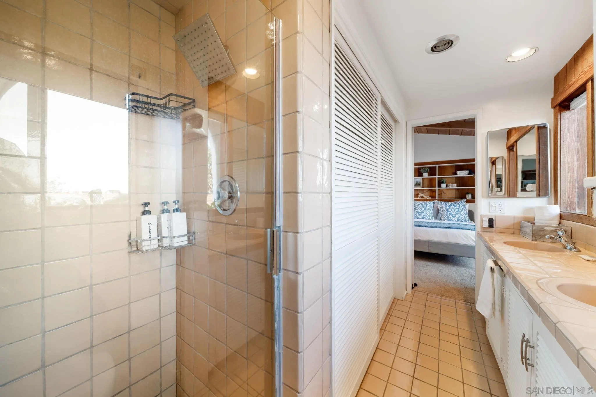 5643 Linda Rosa Avenue La Jolla, CA 92037 - Photo 40 of 56 a en suite bathroom with a granite countertop shower a sink and a mirror