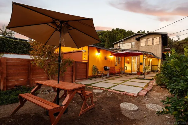 a view of a patio with table and chairs under an umbrella