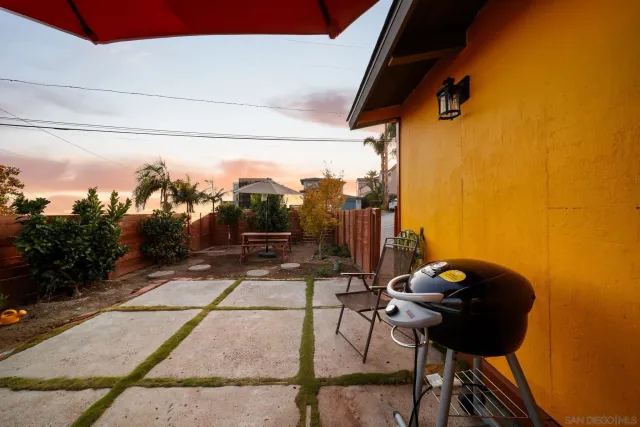 a backyard of a house with table and chairs