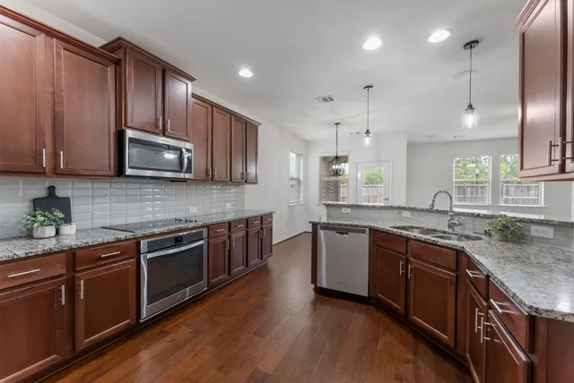 a kitchen with stainless steel appliances granite countertop wooden cabinets stove a sink and dishwasher