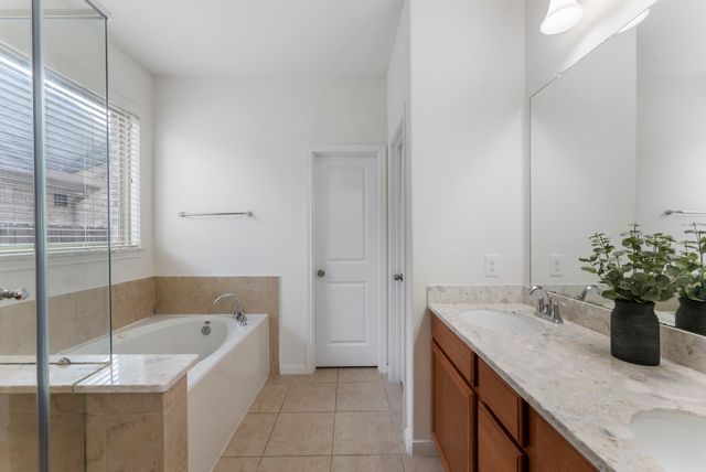 a bathroom with a tub sink and mirror
