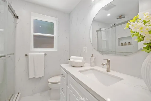 a bathroom with a sink toilet and mirror