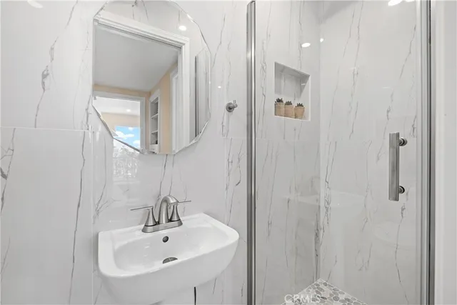 a bathroom with a sink a mirror a vanity and shower