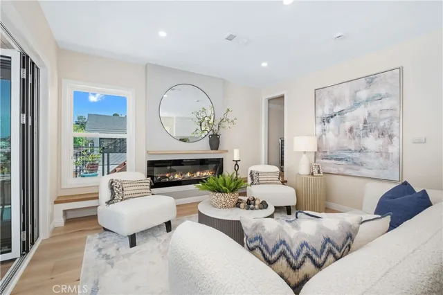 a living room with furniture a fireplace and a large window