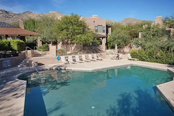a view of a house with pool and a yard