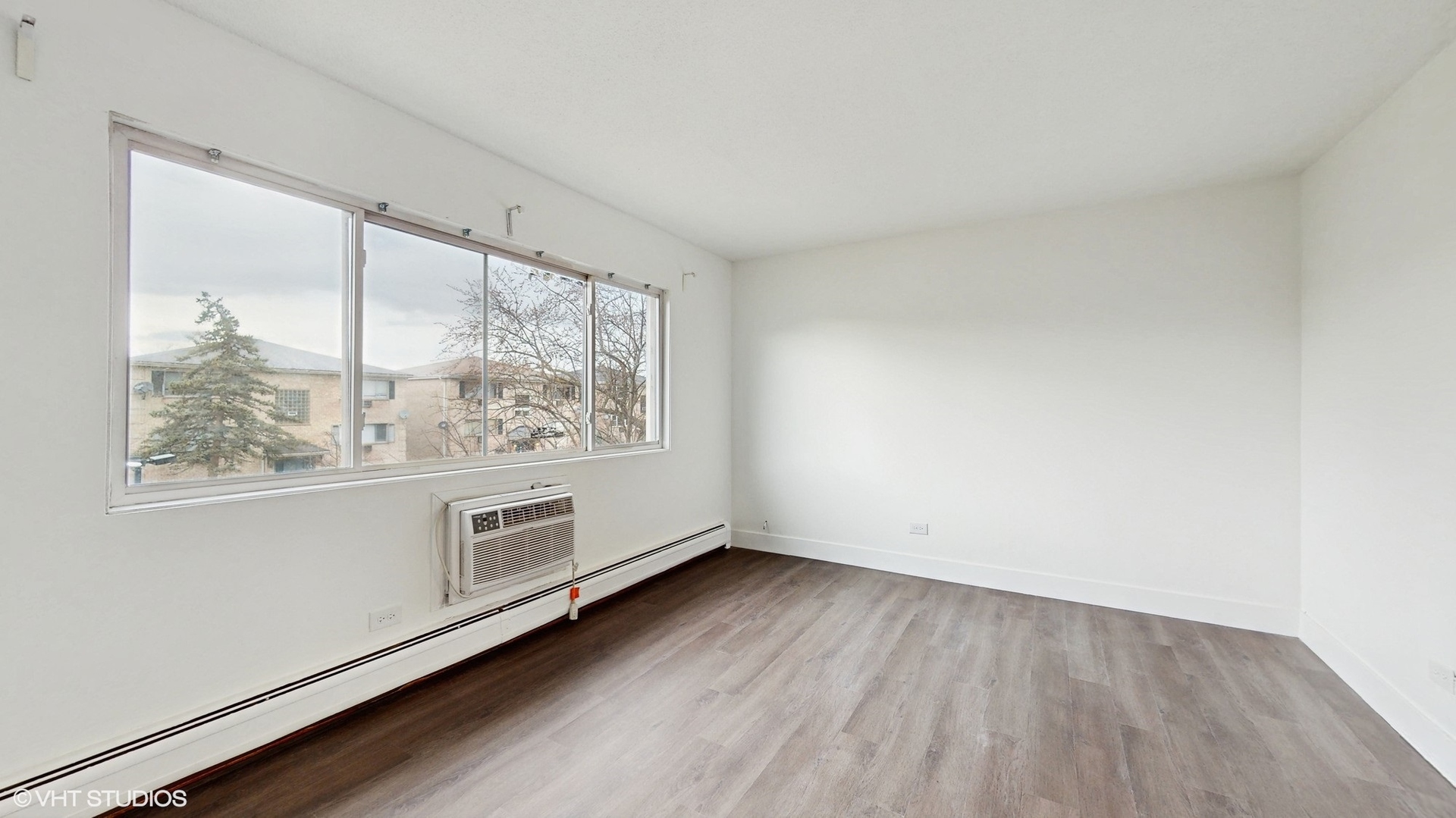 10382 Michael Todd Terrace, Unit GE Glenview, IL 60025 - Photo 4 of 15 an empty room with wooden floor and windows