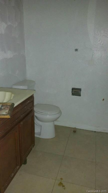 6021 Powder Horn Road Charlotte, NC 28212 - Photo 3 of 10 a bathroom with a granite countertop toilet and a sink