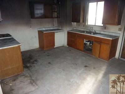 66092 Santa Rosa Road Desert Hot Springs, CA 92240 - Photo 2 of 8 a kitchen with stainless steel appliances granite countertop a sink stove and microwave