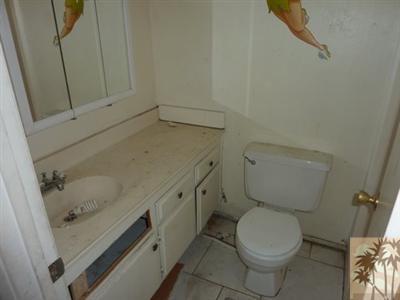 66092 Santa Rosa Road Desert Hot Springs, CA 92240 - Photo 7 of 8 a bathroom with a granite countertop toilet and sink