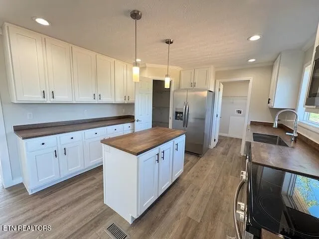 a kitchen with stainless steel appliances granite countertop a sink a stove and a refrigerator