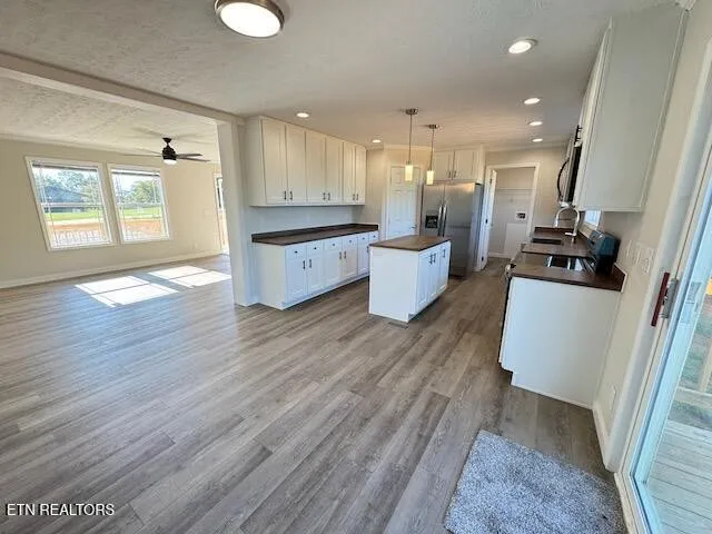 a large white kitchen with wooden floor and a sink