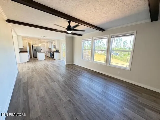 a big room with wooden floor furniture and a ceiling fan