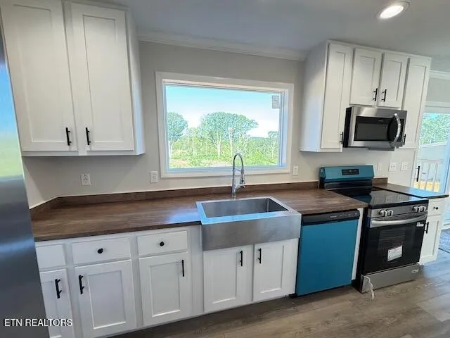 a kitchen with granite countertop white cabinets and a sink