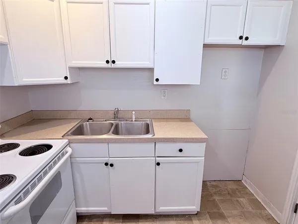 a kitchen with white cabinets and white appliances
