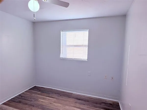 a view of a small space with wooden floor and a window