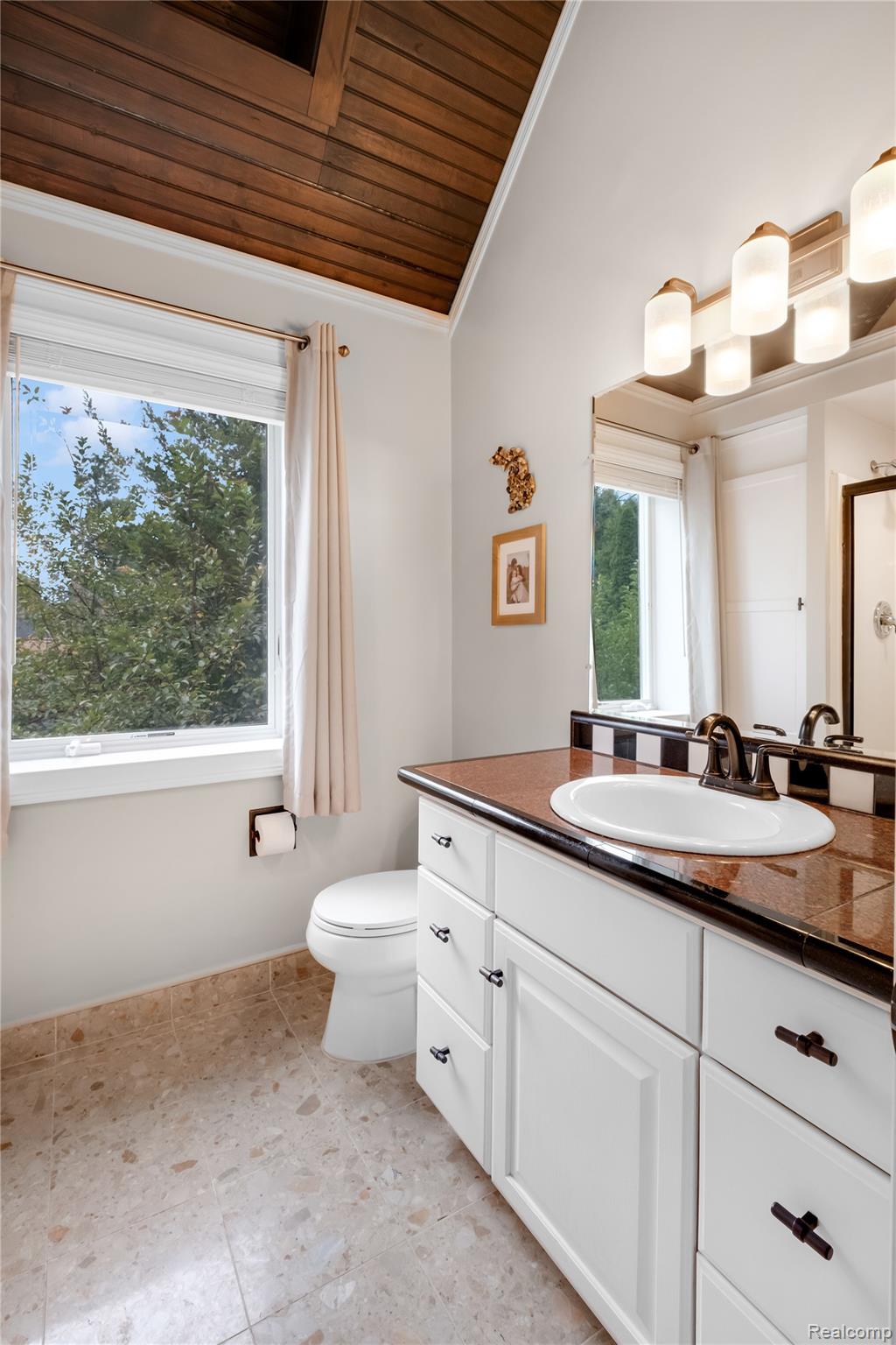 15420 Jennings Road Fenton, MI 48430 - Photo 25 of 45 Vaulted wood-paneled ceiling, white vanity with paneled doors, surface-mounted lighting fixture, and a single basin sink