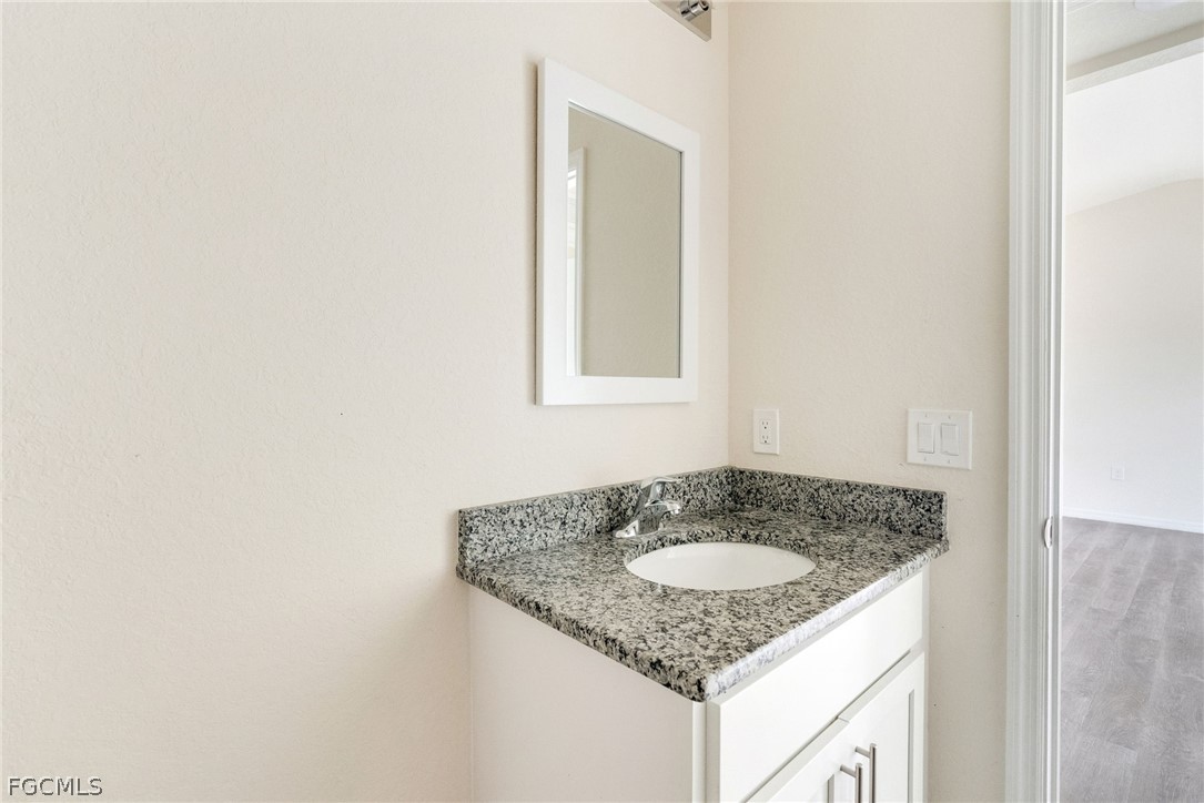1405 Inwood Road LaBelle, FL 33935 - Photo 24 of 35 a bathroom with a granite countertop sink and a mirror